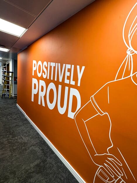 An image of the orange "Positively Proud" wall graphic.